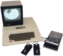 Apple II — Representative product/family photograph. A common 1977 Apple II setup, with a 9" monochrome monitor, game paddles, and a Red Book-recommended Panasonic RQ-309DS cassette deck Resized and re-encoded for this catalogue. Original image licence applies to this resized copy.